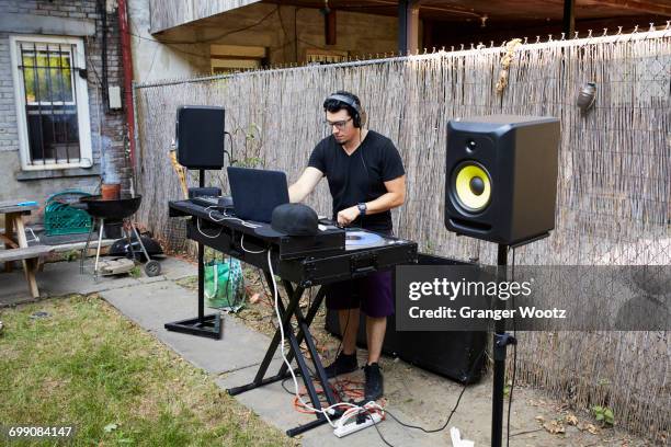 hispanic dj playing music in backyard - backyard deck stockfoto's en -beelden