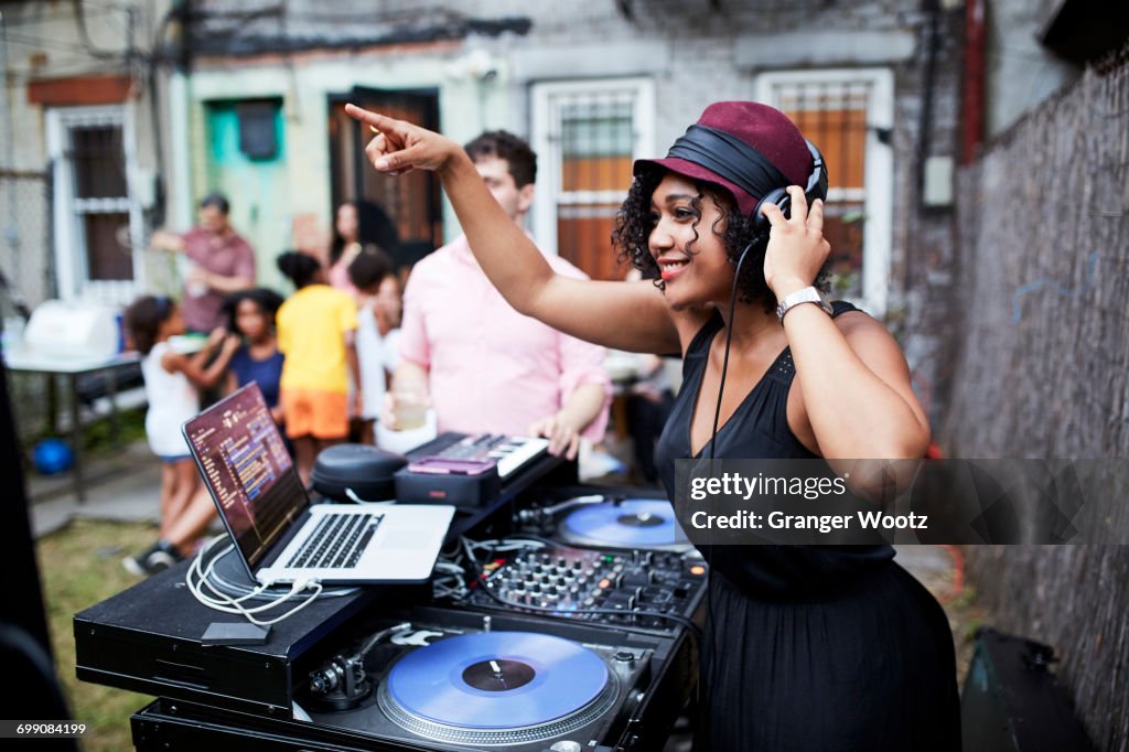 Mixed Race dj playing music at party in backyard