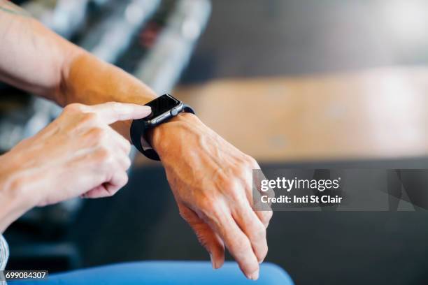 caucasian woman tapping smart watch - checking the time stock pictures, royalty-free photos & images