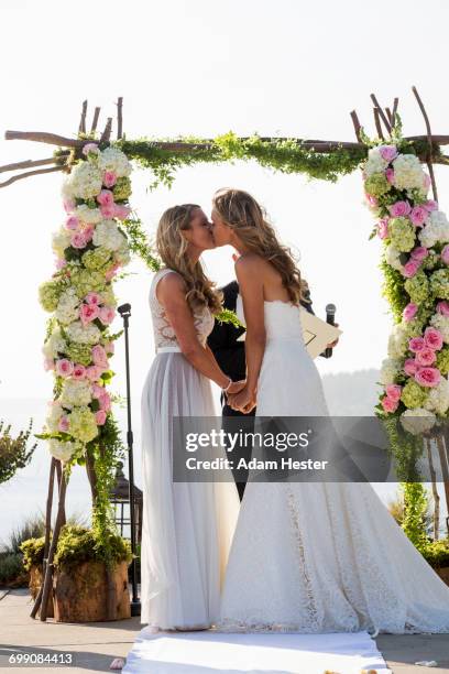 caucasian brides kissing at wedding ceremony - photos of lesbians kissing stock pictures, royalty-free photos & images