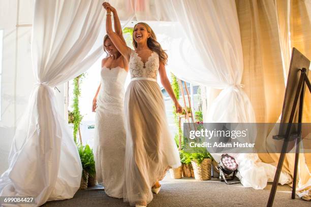 caucasian brides walking through curtain - civil partnership stock pictures, royalty-free photos & images