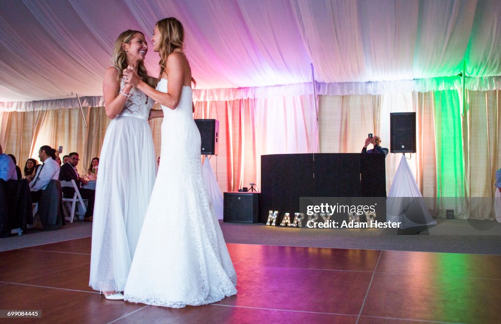 Caucasian brides dancing at wedding