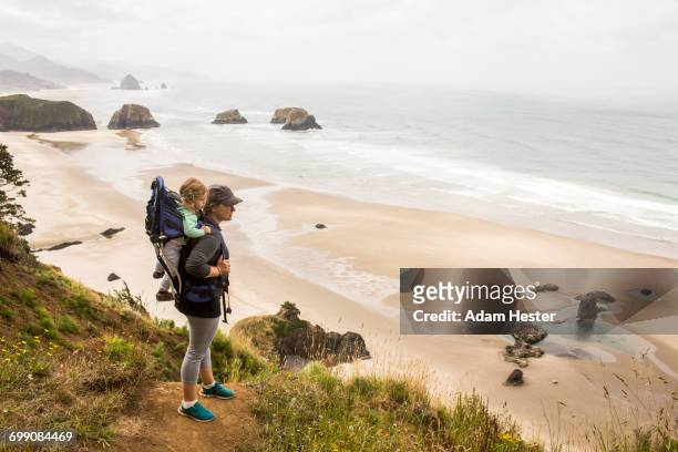caucasian mother carrying daughter on beach - oregon coast stock pictures, royalty-free photos & images