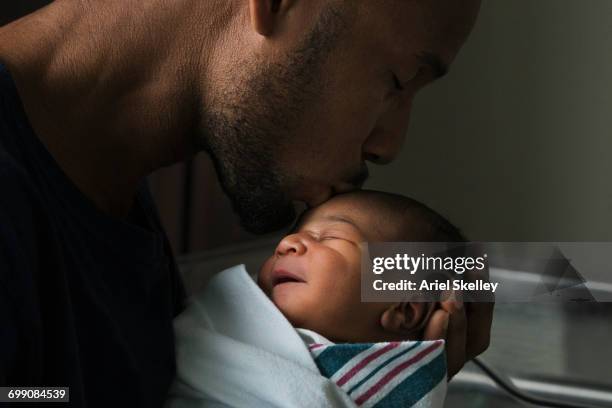 black father kissing forehead of newborn son - love baby imagens e fotografias de stock