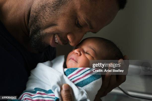 black father admiring newborn son - emotionale momente geburt stock-fotos und bilder