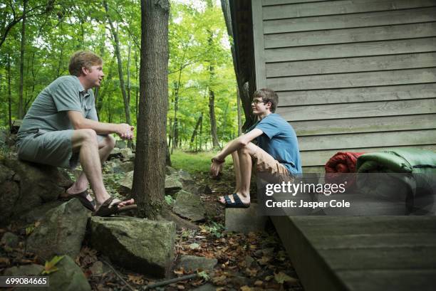 caucasian father and son talking at cabin - nerd shorts stock pictures, royalty-free photos & images