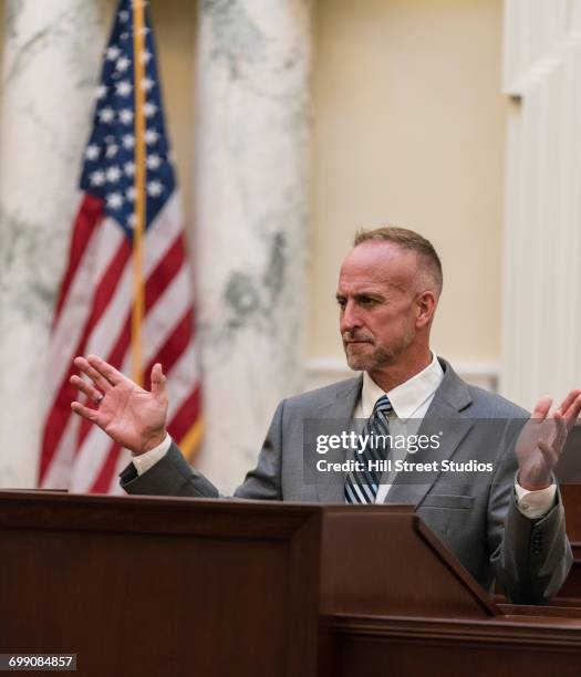 caucasian politician gesturing at podium - tensed idaho stock pictures, royalty-free photos & images