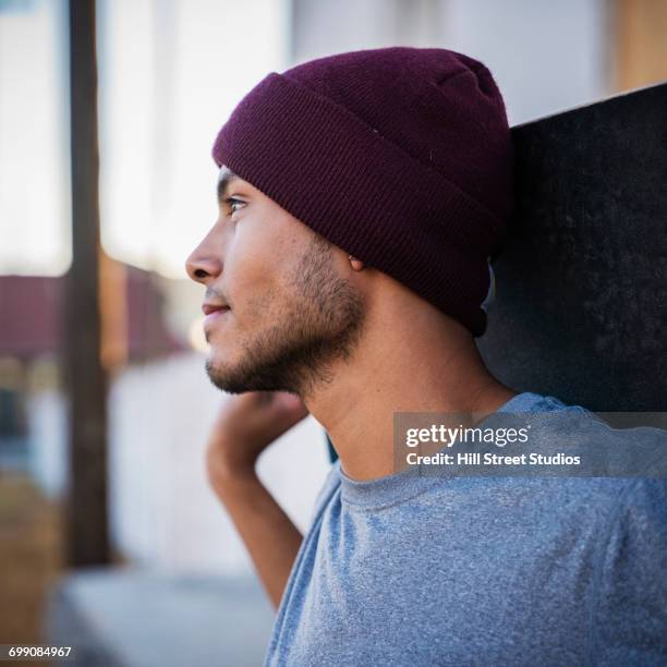 hispanic man holding skateboard - caldwell idaho stock pictures, royalty-free photos & images