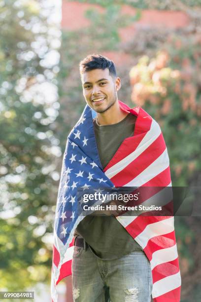 hispanic man wrapped in american flag - caldwell idaho stock pictures, royalty-free photos & images