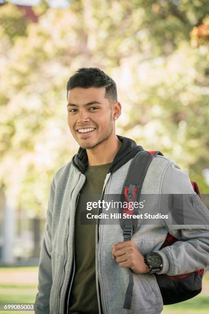 smiling hispanic man carrying backpack - caldwell idaho stockfoto's en -beelden