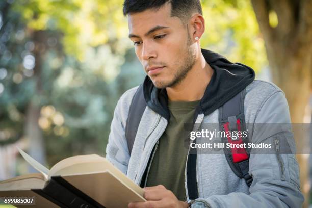 hispanic man reading book - コールドウェル市 ストックフォトと画像