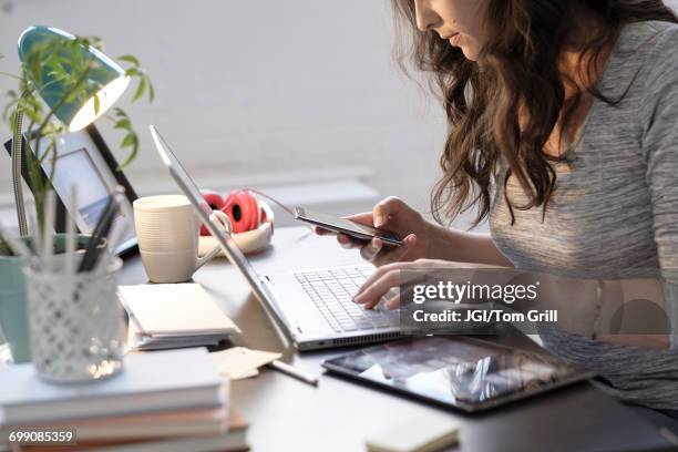 hispanic businesswoman using technology in office - overdoing stock pictures, royalty-free photos & images