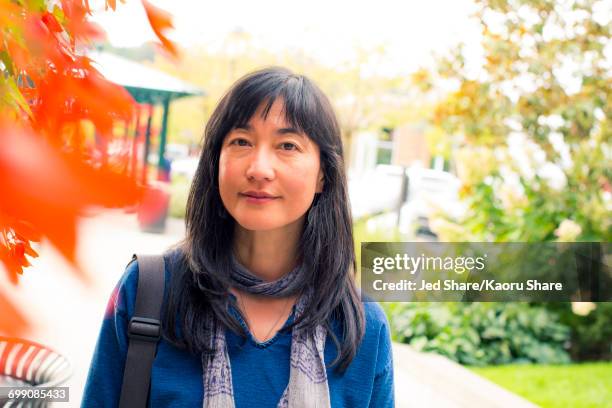 japanese woman smiling near autumn leaves - charming woman foto e immagini stock