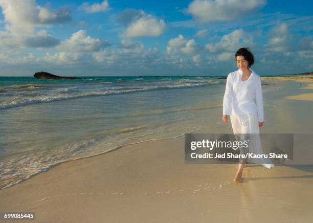 japanese woman walking on beach - skirt blowing fotografías e imágenes de stock