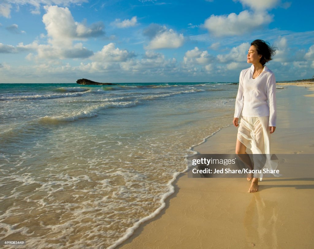 Japanese woman walking on beach