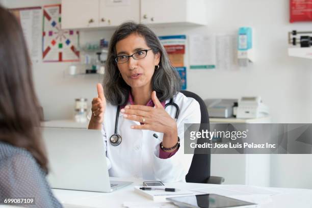 mixed race doctor talking to patient - auscultation woman stockfoto's en -beelden