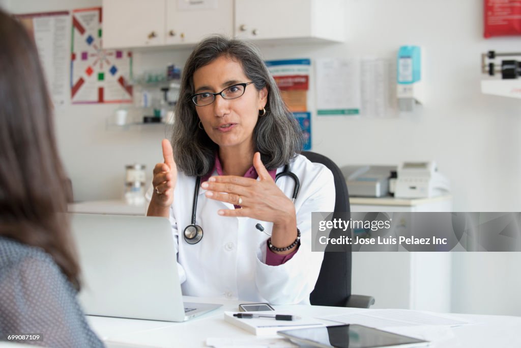 Mixed Race doctor talking to patient