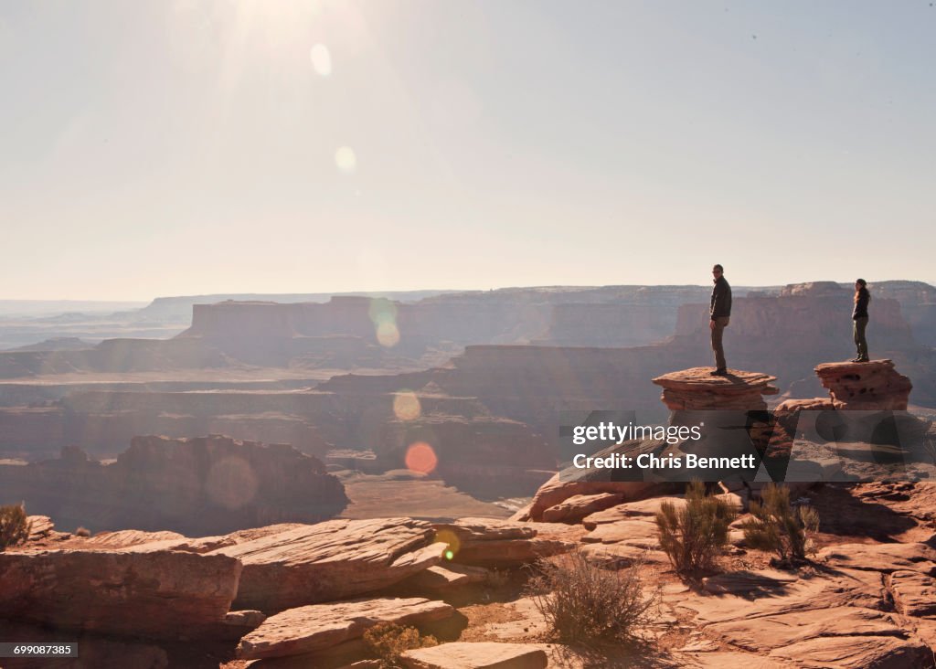 Two figures stand at the canyons edge, Dead Horse Point State Park, Utah.