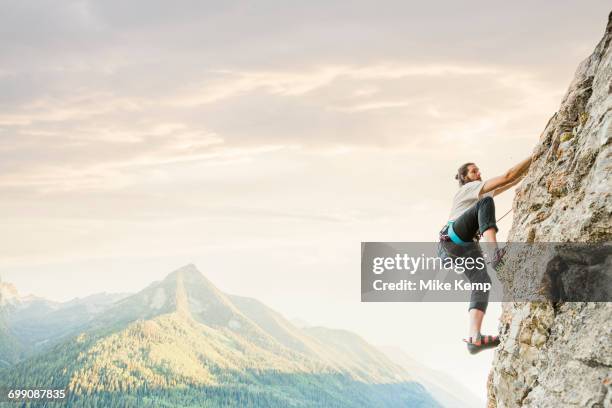 caucasian man rock climbing - cliff side stock pictures, royalty-free photos & images