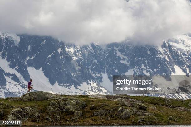 girl trail running in chamonix around the chesery lake - lake chesery stockfoto's en -beelden