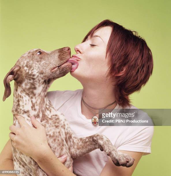 dog licking face of woman - people kissing stock-fotos und bilder