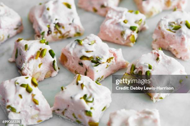 sliced pistachio and rose nougat - nougat stock-fotos und bilder