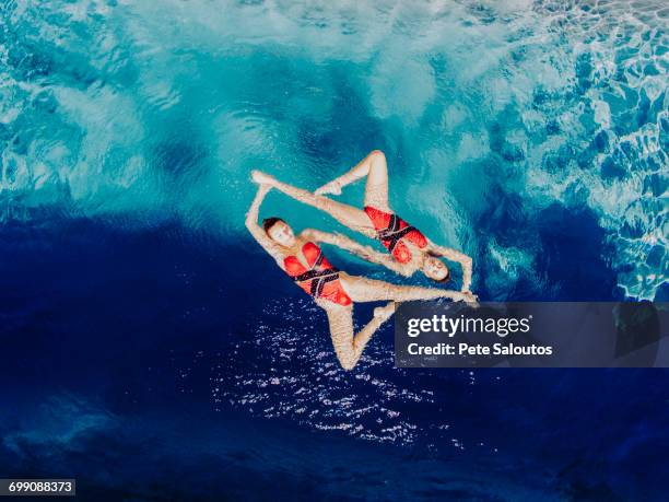 aerial view of caucasian synchronized swimmers - simmetria foto e immagini stock