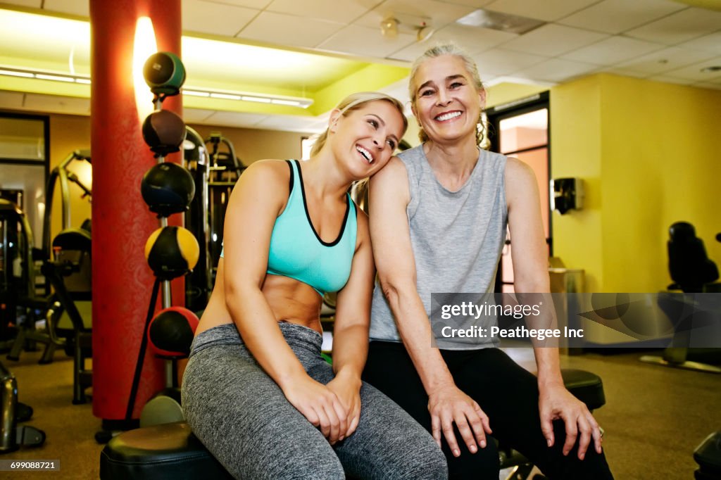 Portrait of smiling Caucasian mother and daughter in gymnasium