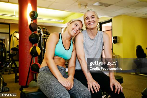 Portrait of smiling Caucasian mother and daughter in gymnasium