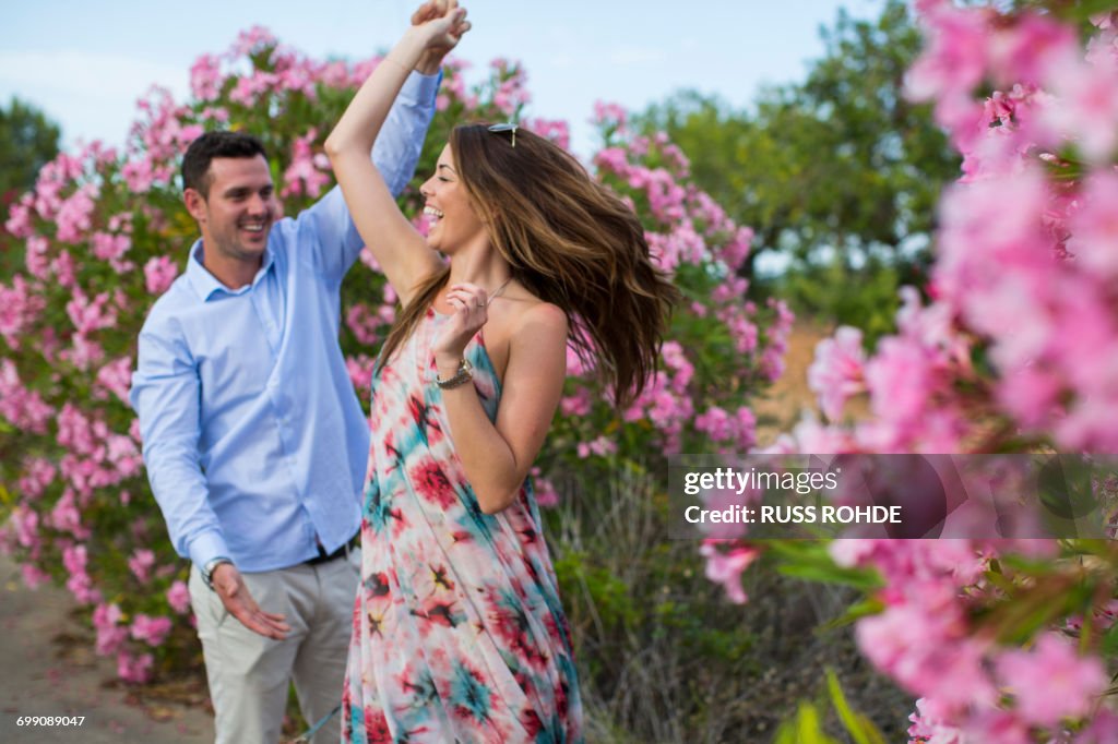 Romantic couple dancing and swirling by blossoms, Majorca, Spain