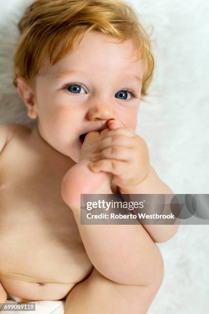caucasian baby boy biting foot - feet sucking stock pictures, royalty-free photos & images