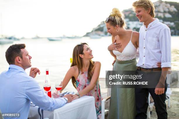 two couples greeting at waterfront restaurant, majorca, spain - four people foto e immagini stock