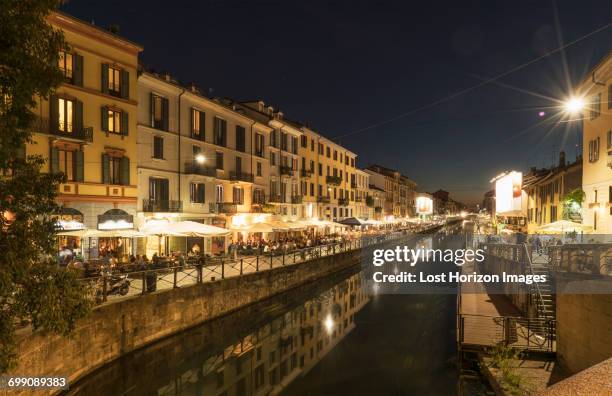 view of canal waterfront in navigli district at night, milan, italy - summit milan stock pictures, royalty-free photos & images