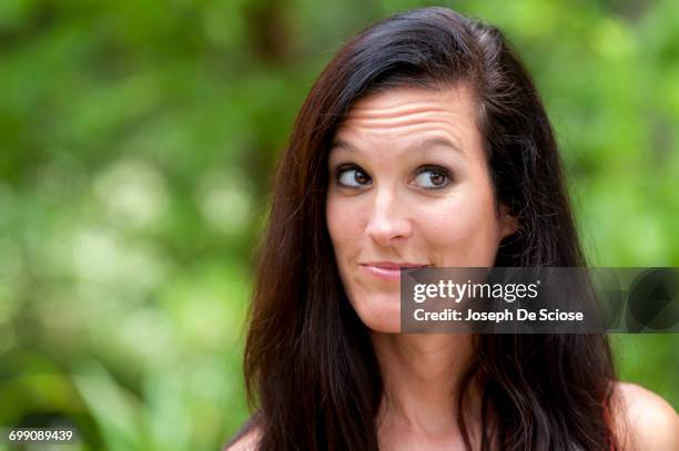 a 38 year old brunette woman outdoors making a face looking away from the camera. - 39 year old stockfoto's en -beelden