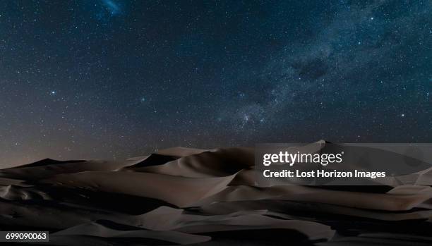 view of dunes under starry night sky, namib desert, namibia - desert night stock-fotos und bilder