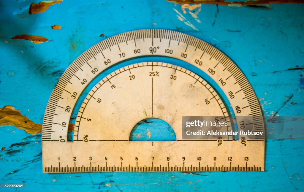 Overhead view of vintage protractor on blue table