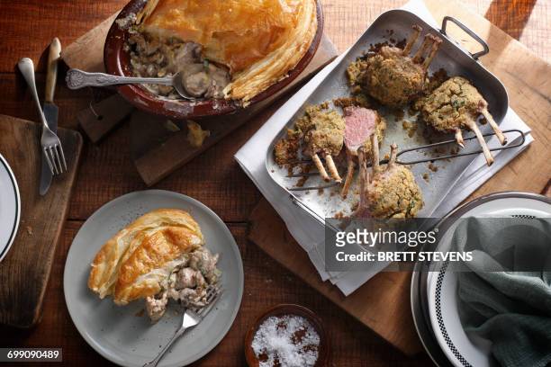bistro table with herb crusted lamb racks and rustic chicken pie - lamb roast fotografías e imágenes de stock