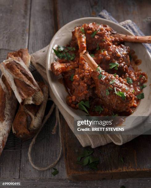 bistro meal of lamb shanks in red wine on table - lamb shank stock pictures, royalty-free photos & images