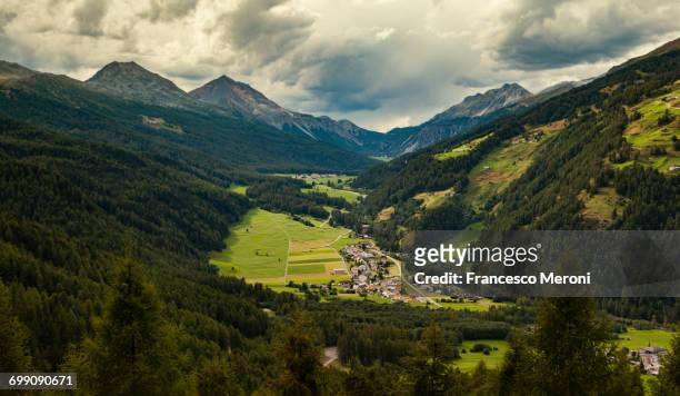 landscape view of mountains and village - val müstair stock-fotos und bilder