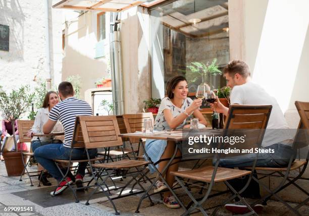 young couples raising a wine toast at sidewalk restaurant, split, dalmatia, croatia - split croatia stock pictures, royalty-free photos & images