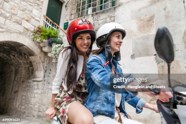 female tourists riding moped through village, split, dalmatia, croatia - riding vespa stock pictures, royalty-free photos & images