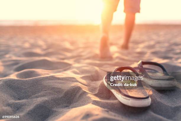 entspannen in der nähe von meer bei sonnenuntergang - flip flops stock-fotos und bilder