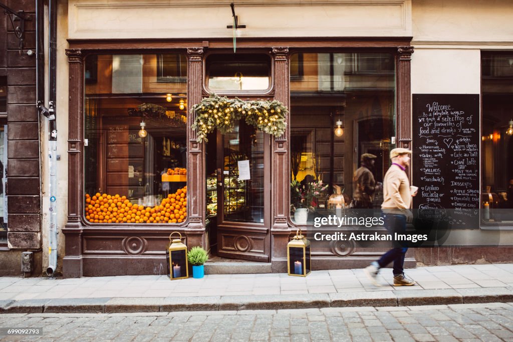 Sweden, Stockholm, Gamla Stan, Man walking by cafe