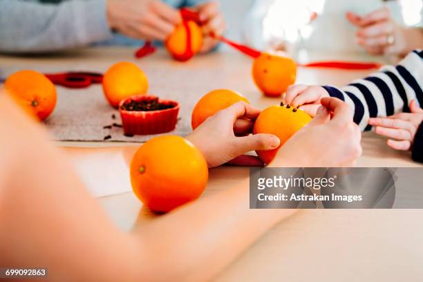 cropped image of family preparing christmas decorations at table - national day celebrations in sweden 2016 imagens e fotografias de stock