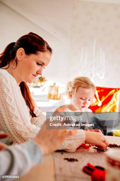family preparing christmas decorations while sitting at table - national day celebrations in sweden 2016 imagens e fotografias de stock