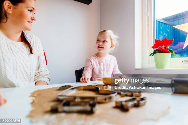 smiling daughter talking to mother while preparing cookies - national day celebrations in sweden 2016 imagens e fotografias de stock