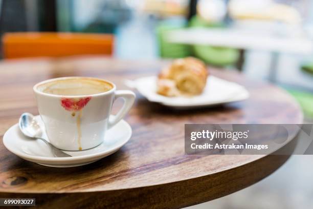close-up of coffee cup with lipstick kiss and croissant on table - lipstick stain stock pictures, royalty-free photos & images