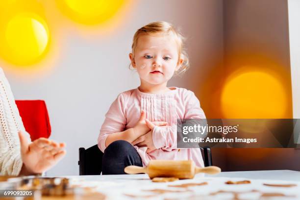 girl looking at pastry dough while standing besides mother - national day celebrations in sweden 2016 imagens e fotografias de stock