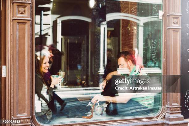 sweden, stockholm, gamla stan, friends having coffee, seen through coffee shop window - fika stock pictures, royalty-free photos & images