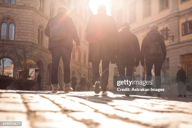 sweden, stockholm, gamla stan, rear view of people walking in old town - four people walking stock pictures, royalty-free photos & images